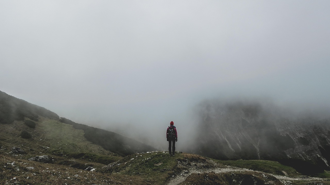 Backpacker walking alone through foggy highlands