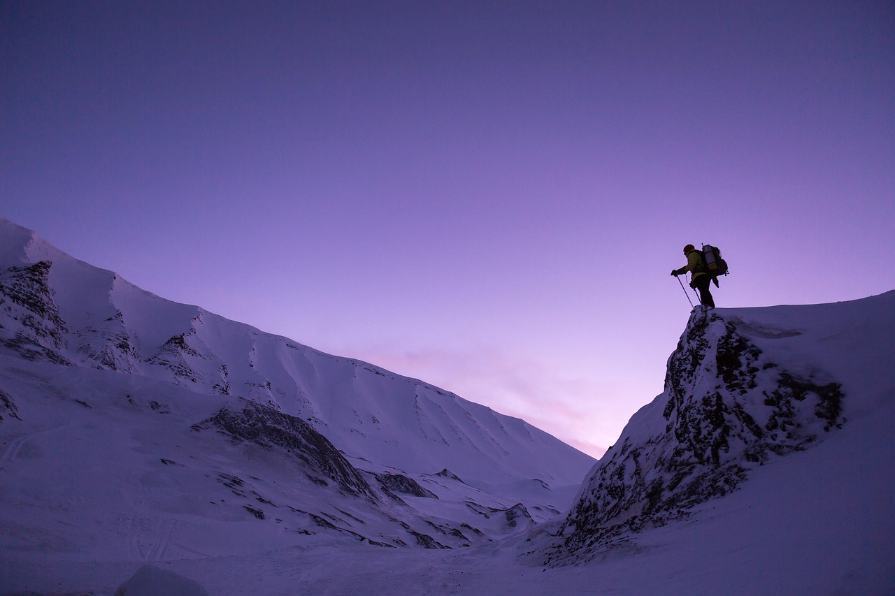 Mountaineer crossing a snowfield at twilight